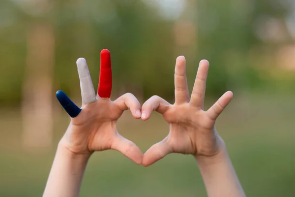 Barnemalte hender malt i fransk flagg Farge som danner et hjertesymbol og kjærlighetsmesse utendørs – stockfoto
