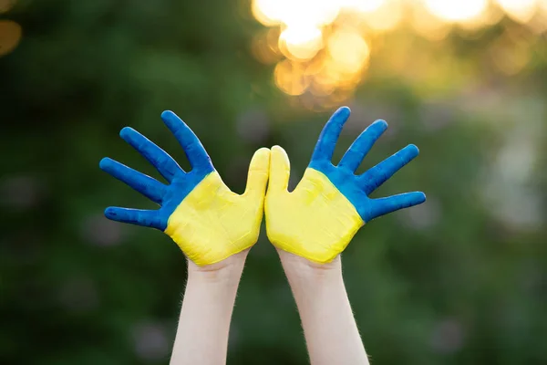 Gadis sekolah kecil menunjukkan tangan dicat dengan warna kuning dan biru. Tangan anak dicat dengan warna biru dan kuning bendera Ukraina. Hari Bendera Kemerdekaan Ukraina. Hari Konstitusi. 24 Agustus. Liburan patriotik — Stok Foto