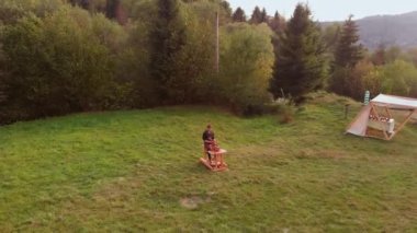 Erkek çömlekçinin çömlekçi çarkında seramik yaparken, killeri sularken ve şekillenirken hava görüntüsü. Potter, elle dönen tekerlekte suyu karıştırarak çömlek kalıbı oluşturur. Sıkı çalışma konsepti