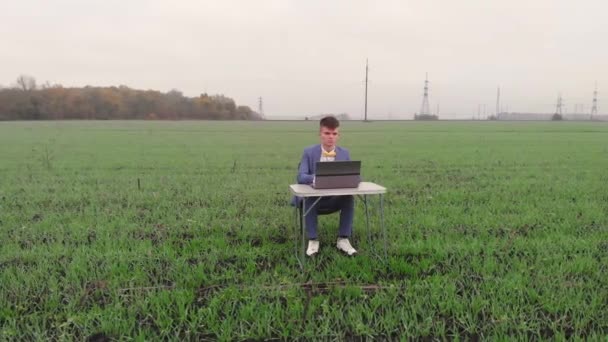 Em volta da visão do estudante sorridente o homem alegra-se com boas notícias da Internet e gestos com as mãos enquanto trabalha no computador portátil no local de trabalho remoto. — Vídeo de Stock