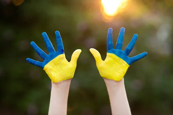 Petite écolière montrant des mains peintes en jaune et bleu. Les mains des enfants peintes en bleu et jaune drapeau de l'Ukraine. Jour du drapeau de l'indépendance ukrainienne. Le jour de la Constitution. 24 août. Vacances patriotiques — Photo