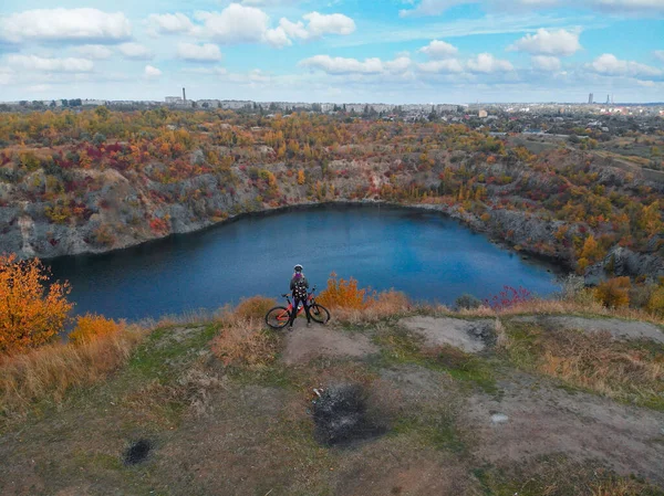 Jeune femme faisant du vélo en plein air vue aérienne d'en haut. Vue aérienne d'une fille sportive heureuse se relaxant près d'un beau lac de montagne, d'un sport et d'un concept de fitness — Photo