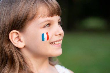 Portrait of child with painted French flag, closeup. Kid fan with blue white red flag painted on face. Education abroad. 14 July, Bastille day, France national holiday clipart