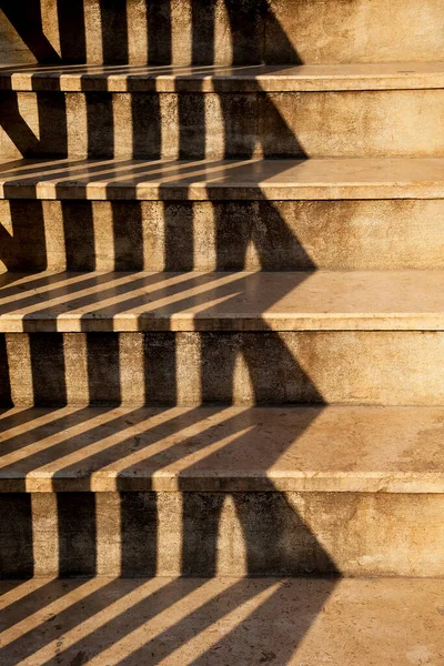 Işık beton merdivenlere çarpar..