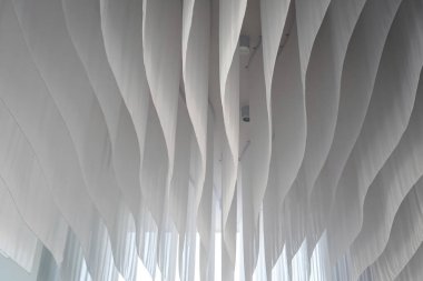 Odanın tavanı dalgalar gibi beyaz kumaşla süslenmişti..