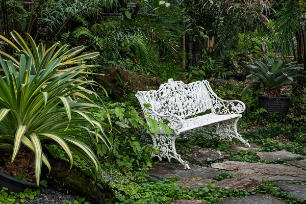 white iron bench in the backyard garden