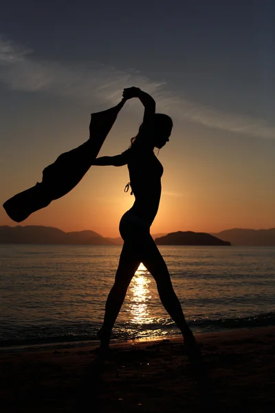 Silhouet van een meisje op het strand — Stockfoto