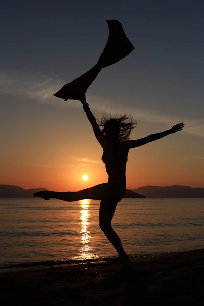 女性運動服でポーズビーチで女の子のシルエット — ストック写真