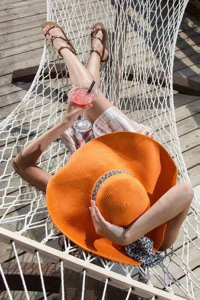 Menina bonita relaxante em uma rede com um coquetel — Fotografia de Stock