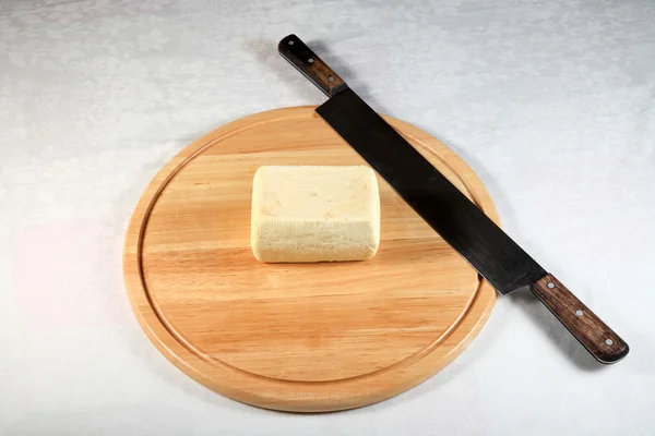 Block of cheese on a wooden plate with decoration — Stock Photo, Image