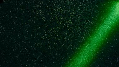 Multi-colored beams of light blink on a dark background.