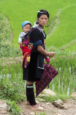 Woman carries her child on the back