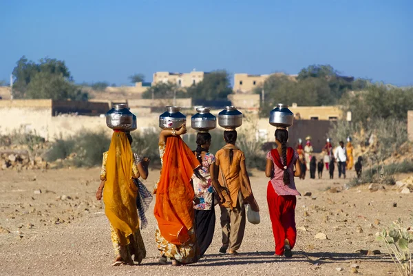 Vrouwen sjouwen water pot op hoofd — Stockfoto