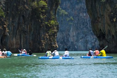 turistler kayık ile kireçtaşı kayalıklarla