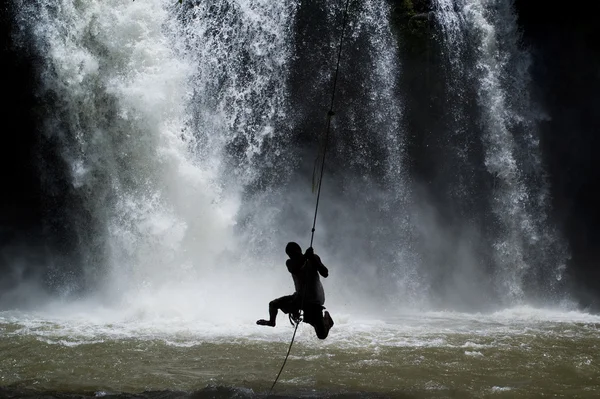 Man svänger sig själv vid ett vattenfall — Stockfoto