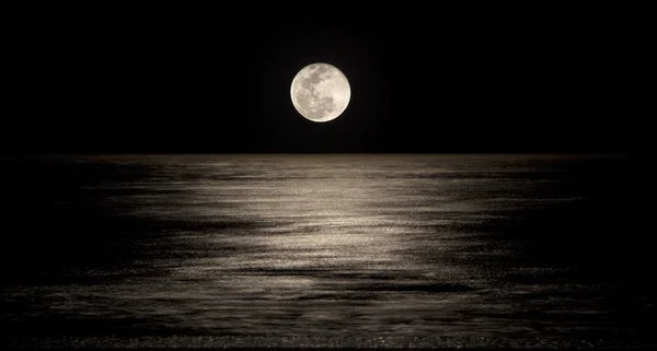 Måne över havet Stockfoto