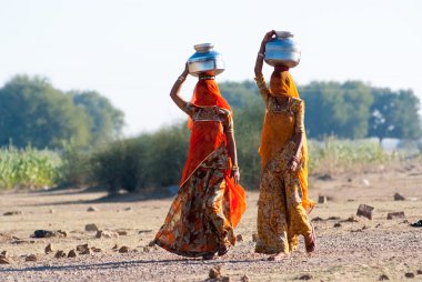women lugging a water pot on their head clipart
