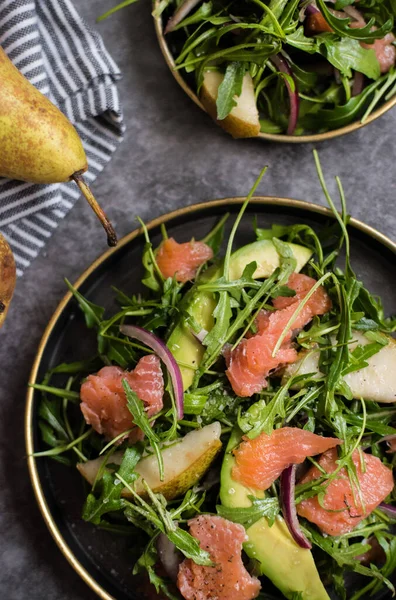 Tabakta sağlıklı avokado, somon ve roka salatası.