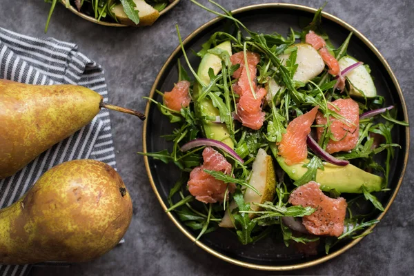 Tabakta sağlıklı avokado, somon ve roka salatası.
