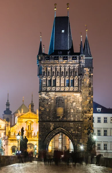 Mirar fijamente a la Torre Mesto desde el Puente de Carlos por la noche, Praga . — Foto de Stock