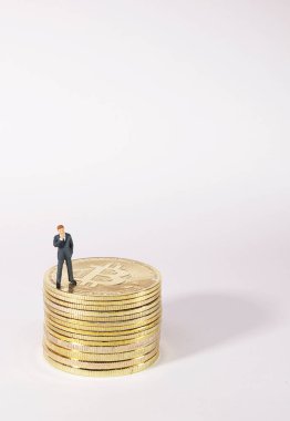 Bitcoin 'in üzerinde duran iş adamı figürü. Bitcoin madencilik kavramı.