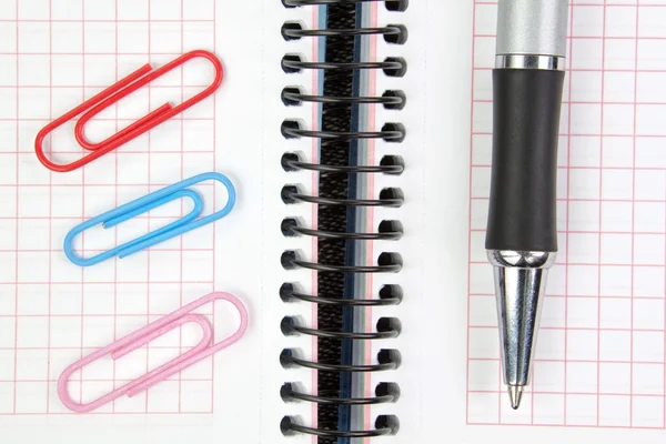 Notebook, pen and paper clips close up. — Stock Photo, Image