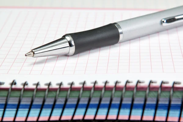 Named ballpoint pen. On the notebook into the cell. — Stock Photo, Image
