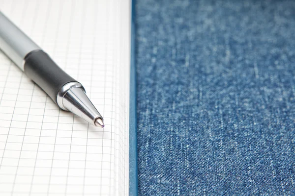 Named ballpoint pen. On the background of notebooks and jeans. — Stock Photo, Image