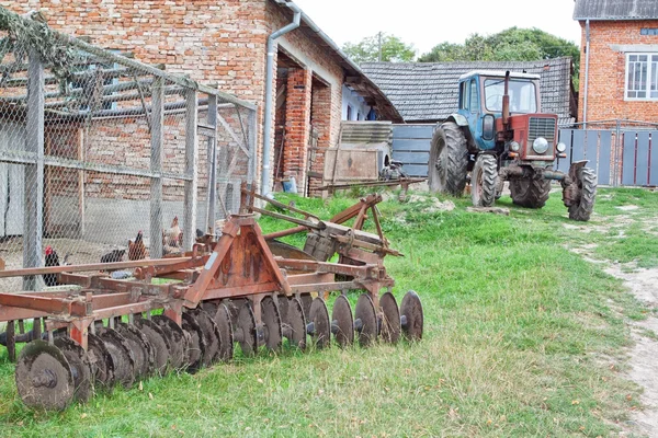Antiguo tractor y arado en la granja. — Foto de Stock