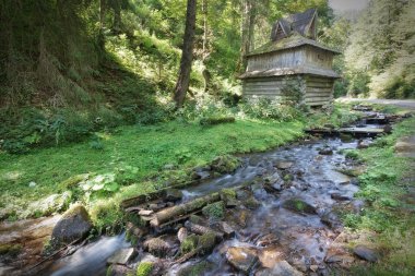 Ahşap evin yakınındaki dağ orman dere akar.