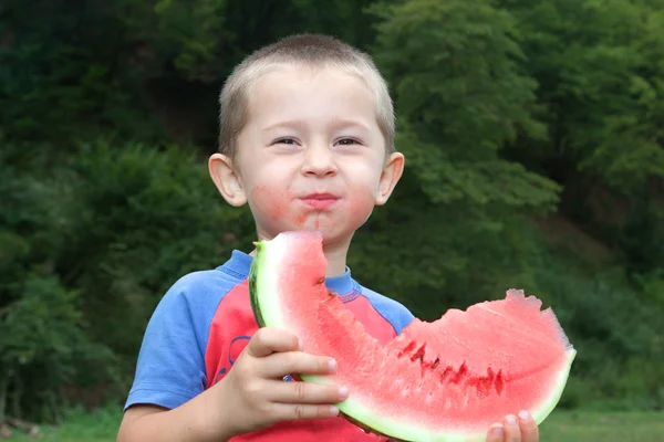Jolly boy eating greedily tasty watermelon. — Stock Photo, Image