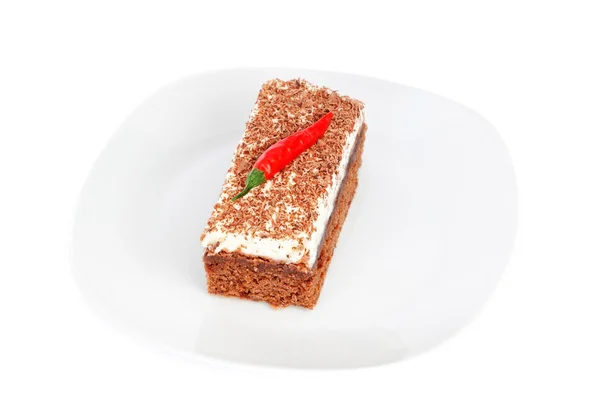 Piece of cake on a plate, and the fruit of paprika. — Stock Photo, Image