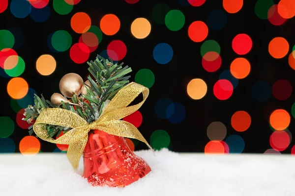 Ein Weihnachts-Bell im Schnee. auf dem Hintergrund bokeh. — Stockfoto