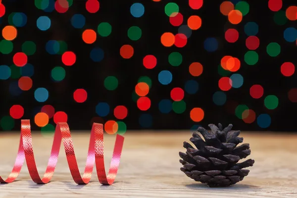 Cone on the texture of wood and ribbon on the background bokeh. — Stock Photo, Image