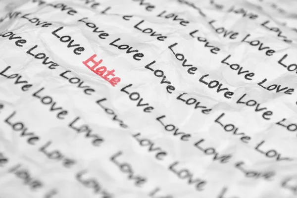 O ódio de palavra, amor, escrito em um pedaço de closeup amassado. — Fotografia de Stock