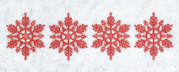 Чотири декоративних різдвяних сніжинки крупним планом на снігу . — стокове фото