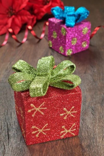 Christmas gifts with ribbons on wooden texture closeup. — Stock Photo, Image