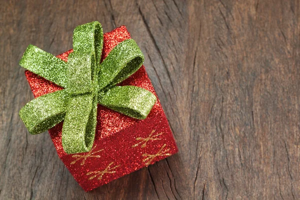 De doos van de gift van Kerstmis met een strik op een houten textuur close-up. — Stockfoto