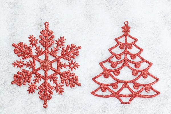 Decorative red Christmas tree and snowflake on white snow. — Stock Photo, Image