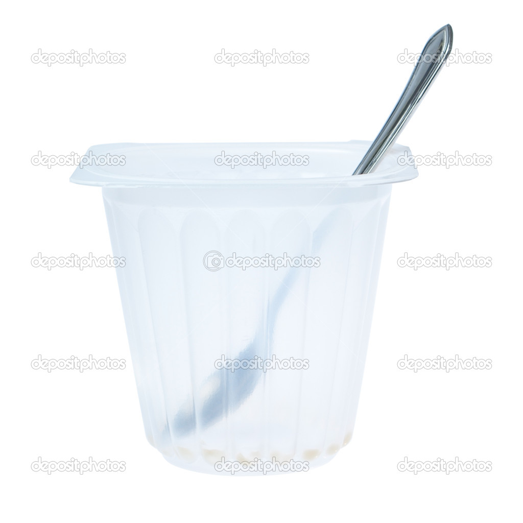 Empty cup of yogurt with a spoon. On a white background.