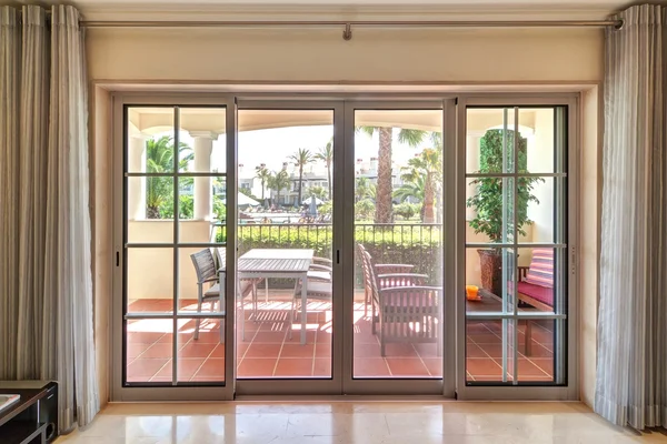 Zimmer Fenster mit Blick auf die Terrasse und grüne Gärten. — Stockfoto