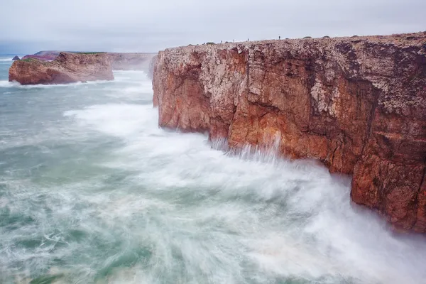 Small fishermen on a giant rock in a storm. — Stock Photo, Image