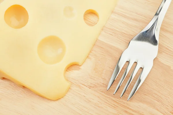 Tasty-grade cheese on a board with a fork. Concept. — Stock Photo, Image