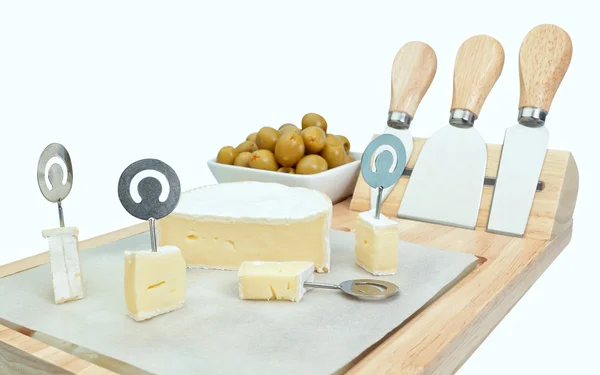 Cut cubes cheese on a wooden board with olives. Close-up. — Stock Photo, Image