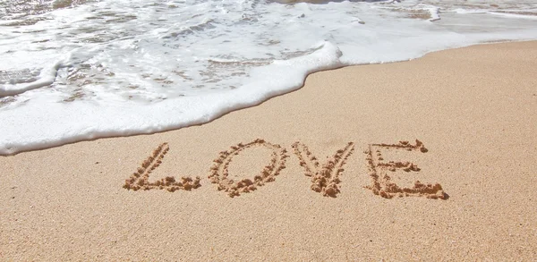 Le mot amour dans la mer sur la plage de Saint-Valentin. Closeup. — Photo