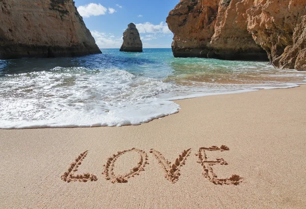 Slovo láska v písku na pláži na Valentýna — Stock fotografie