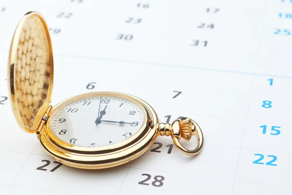 Antique pocket watch on a calendar. — Stock Photo, Image