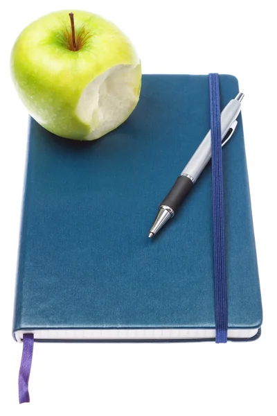 Manzana mordida en cuaderno de bloc de notas y bolígrafo. en un blanco b —  Fotos de Stock