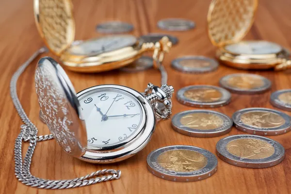 Reloj de bolsillo del grupo contra el fondo de monedas de euro. — Foto de Stock