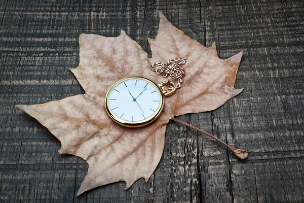 Reloj de bolsillo las hojas de otoño. en una textura de madera. —  Fotos de Stock